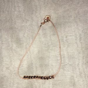 Gold beaded bracelet on light pink cloth!